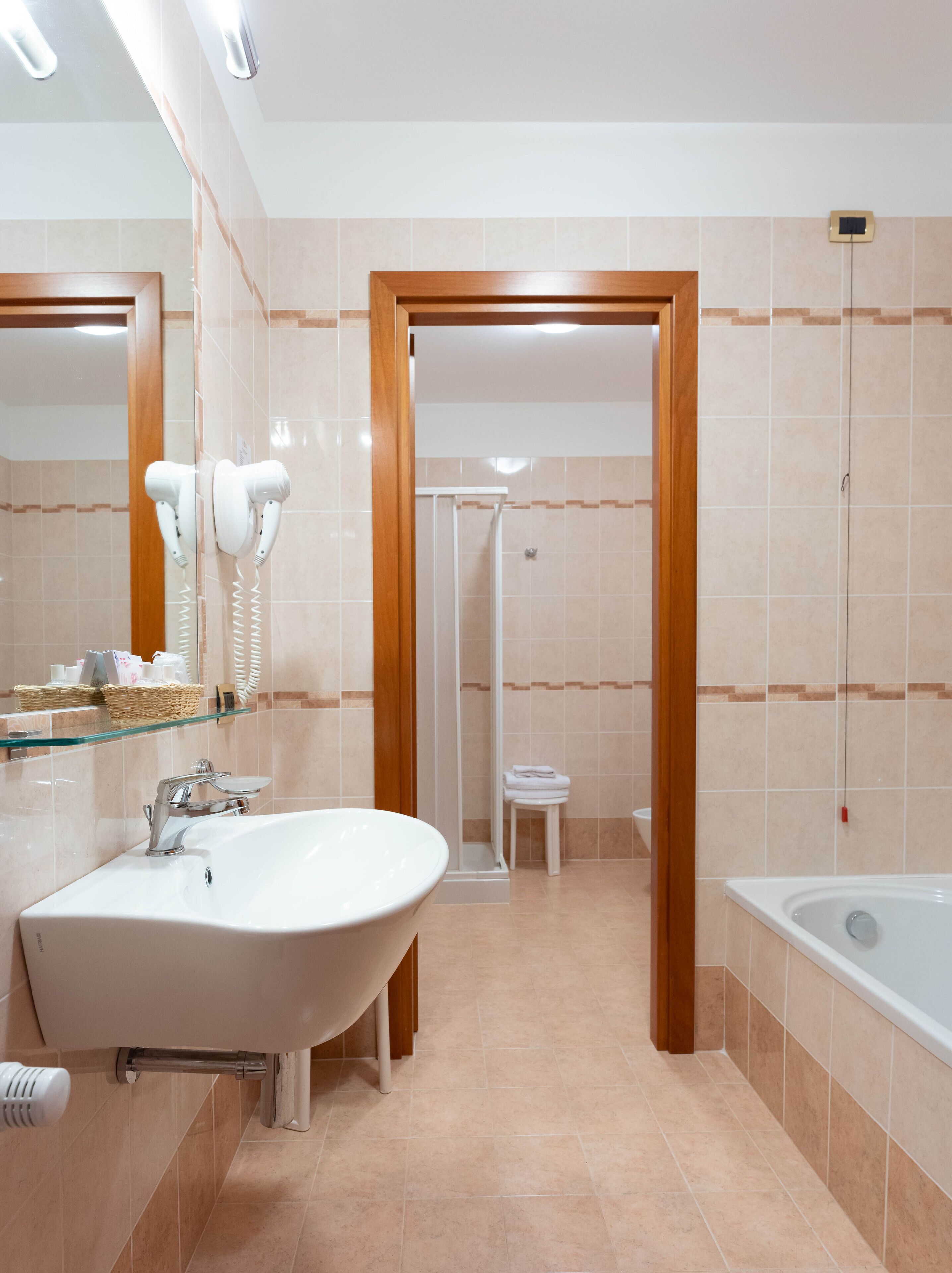 Un baño moderno con una bañera independiente, un tocador con cristalera y un espejo grande, y una zona de ducha con puerta de cristal.