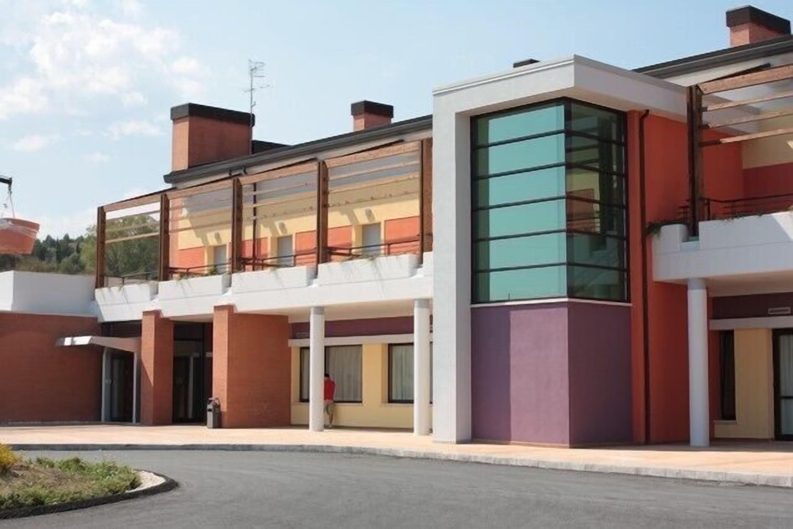 Un bâtiment moderne doté d’une façade en verre, d’un toit plat et d’une cour intérieure.