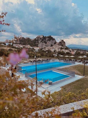 Una piscina al aire libre de temporada, sombrillas