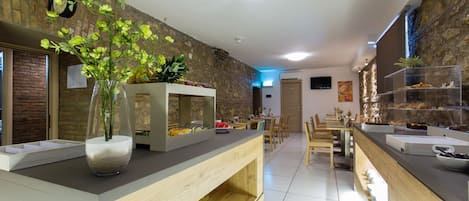 A modern dining area with a buffet setup, wooden furniture, and a stone accent wall.