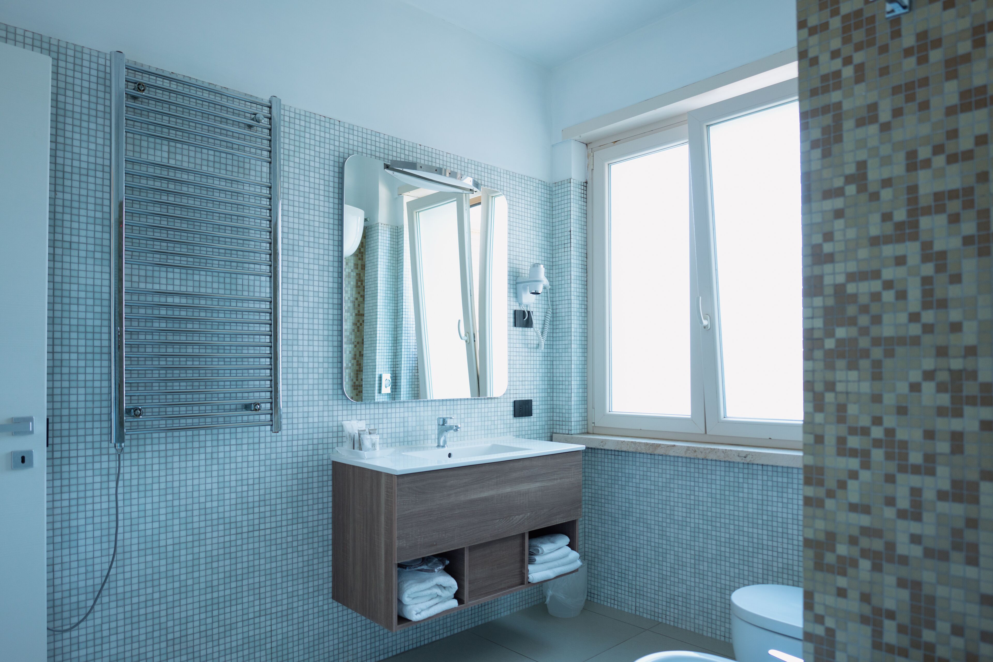 Un bagno moderno con un grande specchio, un lavandino e un water.