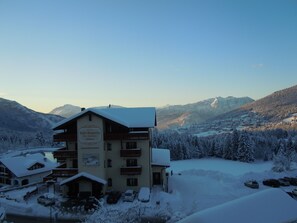 A hotel with multiple floors, a sign indicating it is a bar, restaurant, and wellness center, surrounded by snow-covered trees and mountains in the background. - Seggiovia (Folgaria)
