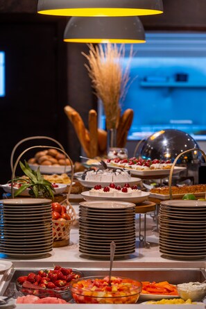 A buffet with various food items and a decorative vase with dried plants.