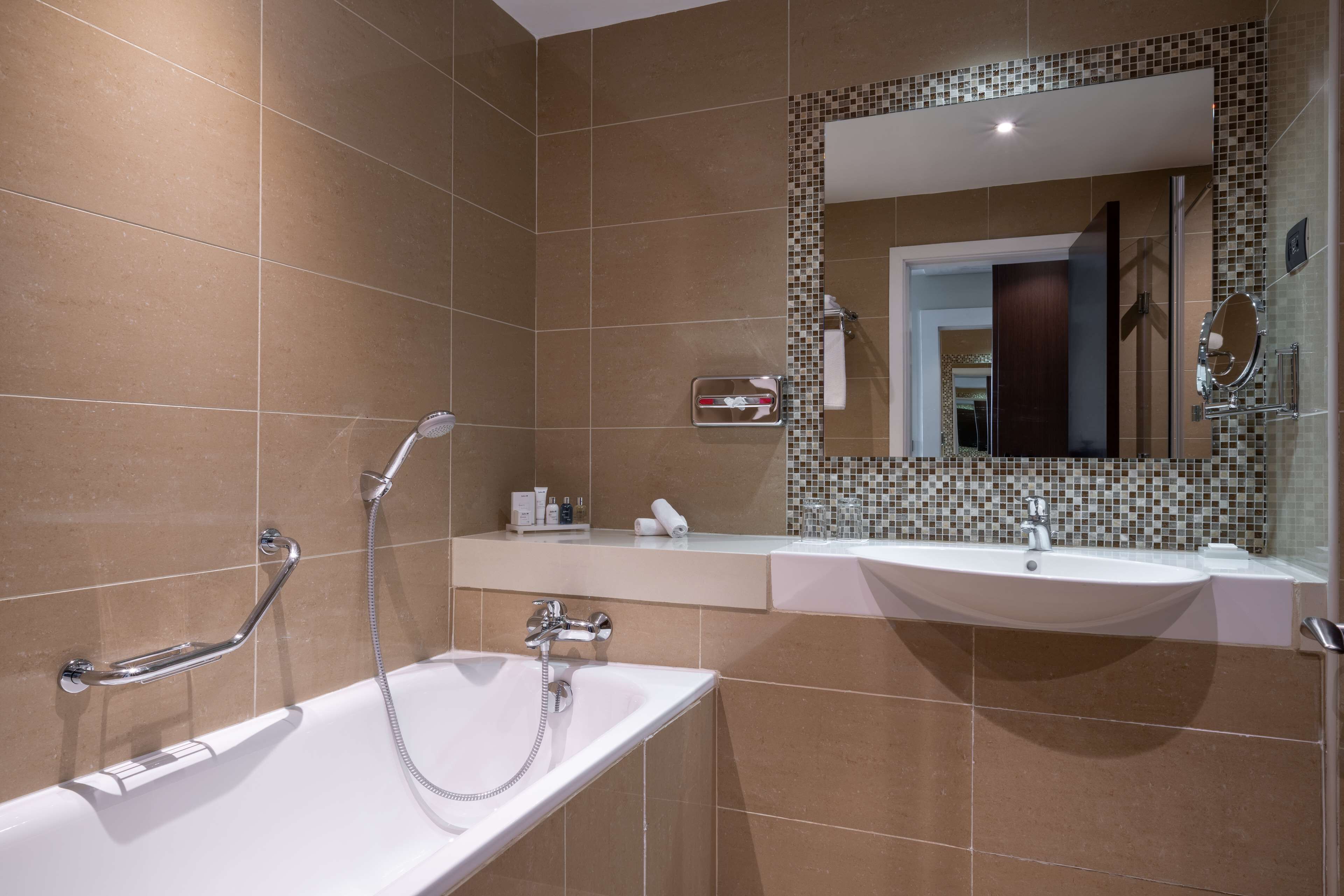 Un baño moderno con una bañera, un lavabo y un espejo.