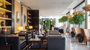 A modern lobby with sofas, tables, and decorative vases.