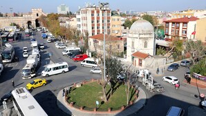 A city intersection with a roundabout, buildings, and vehicles. - Yavuz Otel (Istanbul)