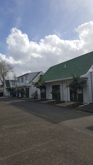 A two-story building with a green roof and a paved driveway. - Auckland Northshore Motels & Holiday Park (Auckland)