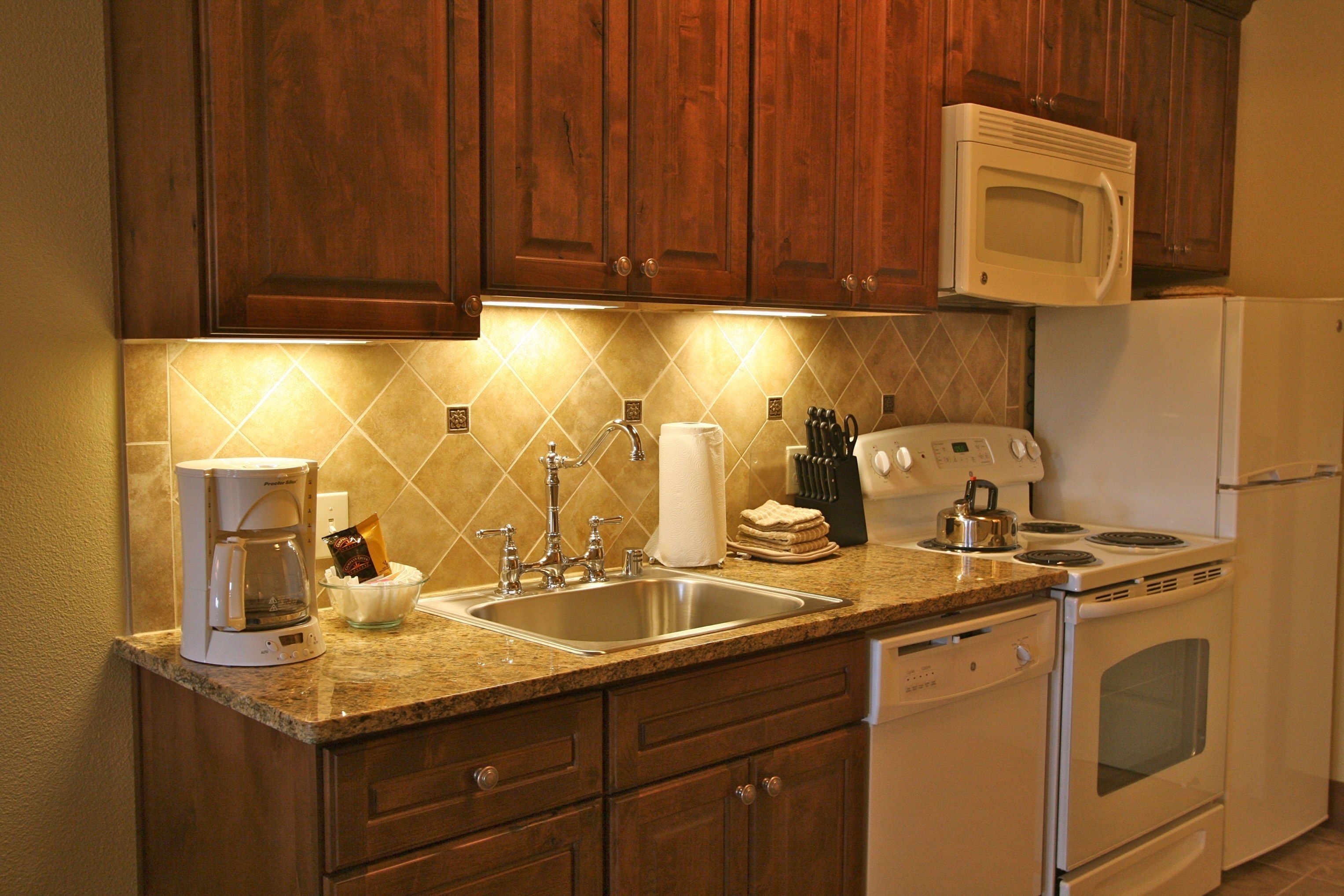 A kitchen with wooden cabinets, a microwave, a stove, and a dishwasher.
