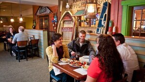 Een restaurant met een rustieke inrichting, houten tafels en diverse gerechten op de tafels.