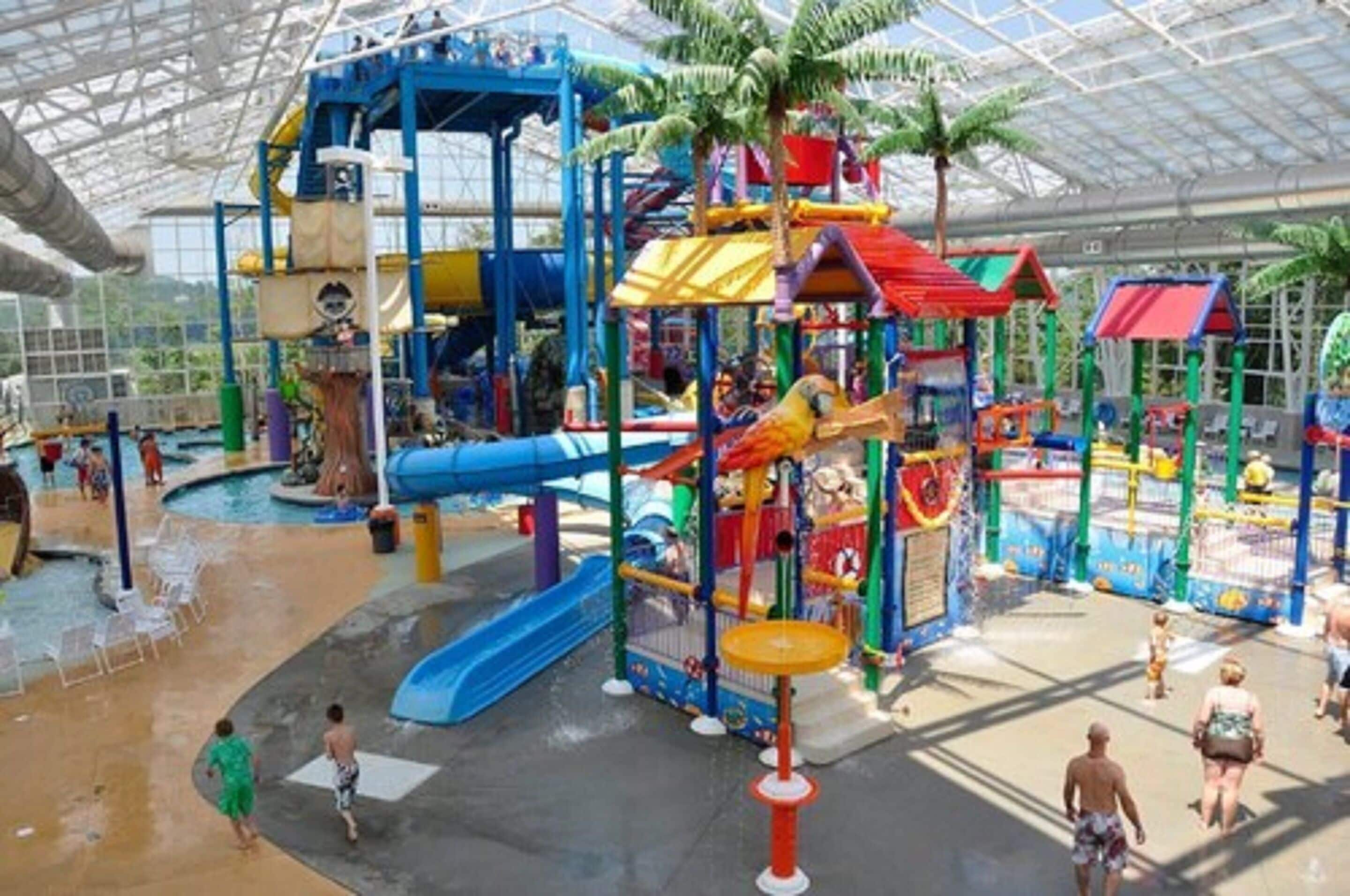 An indoor water park with slides, play structures, and a covered area.