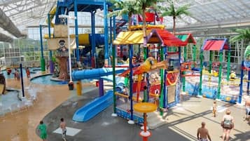 An indoor water park with slides, play structures, and a covered area.