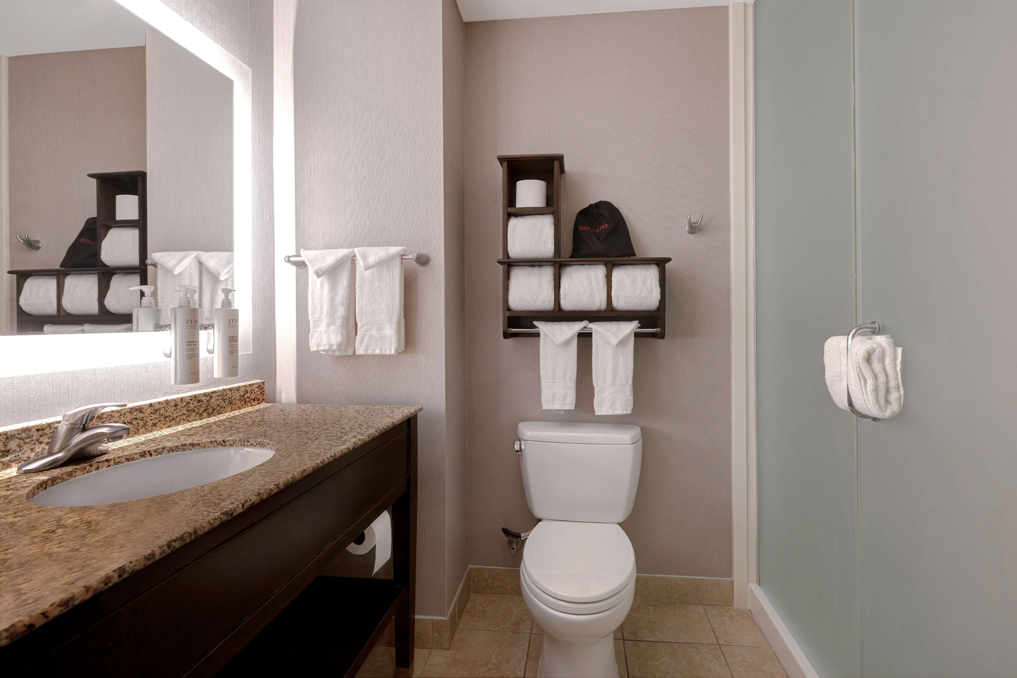 Une salle de bain équipée d’un lavabo, de toilettes et d’un porte-serviettes.