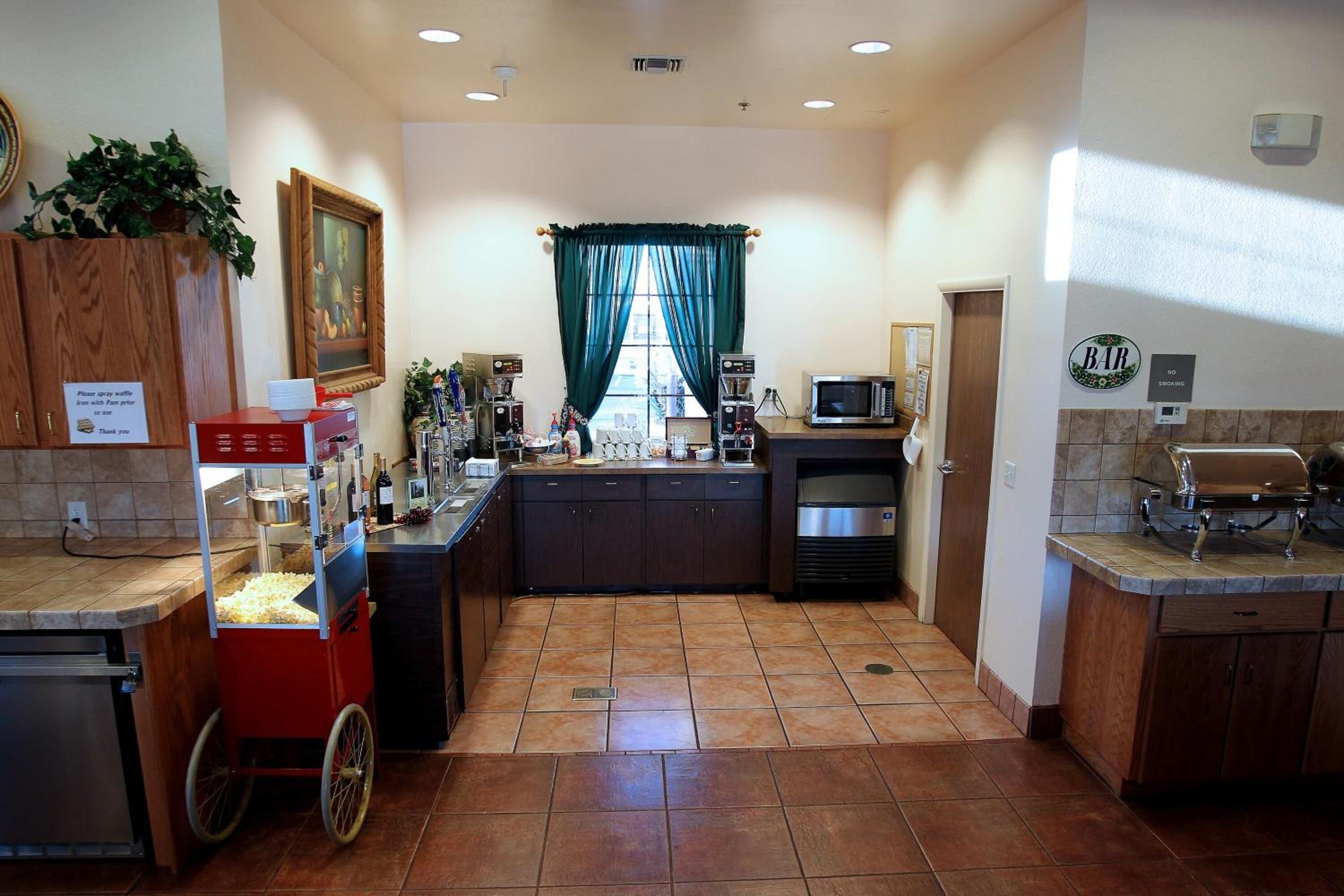 A kitchen with a popcorn machine, microwave, and coffee maker.