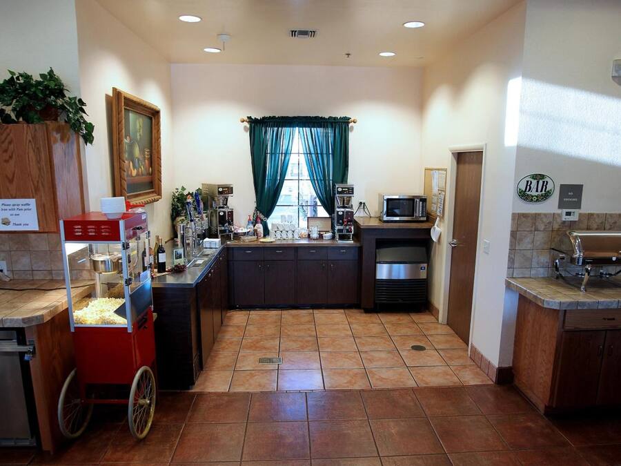 A kitchen with a popcorn machine, microwave, and coffee maker.