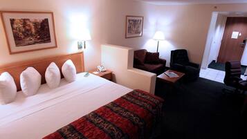 Una habitación de hotel con una cama grande, un escritorio, una silla y dos lámparas.