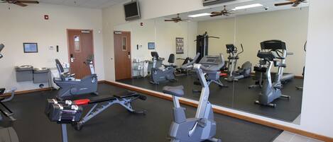 A gym with stationary bikes, treadmills, and exercise equipment.
