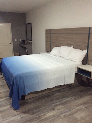 A standard hotel room with a bed, bedside table, and a small desk. - Crystal Inn Houston North I-45 (Houston)