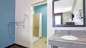 A bathroom with a sink, mirror, towel rack, and a shower area. - Crystal Inn Houston North I-45 (Houston)