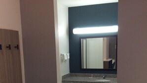 A bathroom with a sink, mirror, and towel rack.