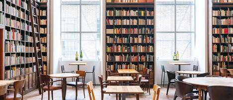 Eine Bibliothek mit Bücherregalen, Tischen und Stühlen.