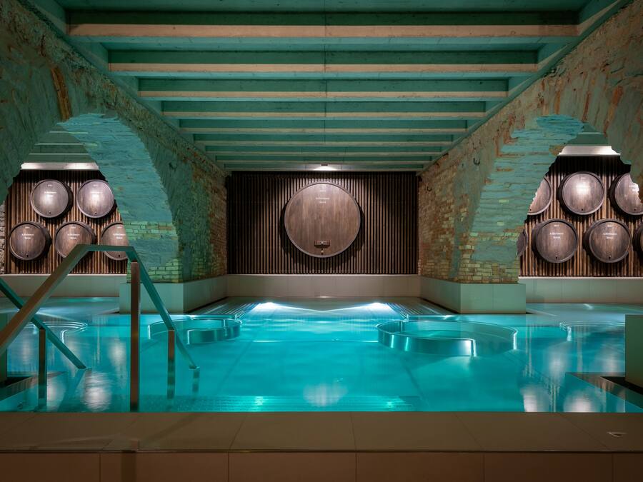 A swimming pool with wooden barrel walls and a central wooden panel.