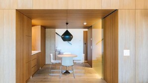 A modern interior with wooden paneling, a round table with chairs, and a hanging light fixture. - B2 Hotel Zürich (Zürich)
