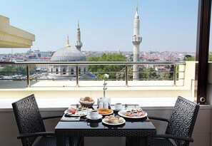 A balcony with a table set for breakfast, overlooking a cityscape with prominent minarets and a dome. - Grand Durmaz Hotel (Istanbul)