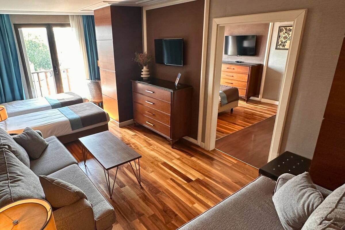 A modern living room with a sofa, coffee table, and a TV mounted on the wall.