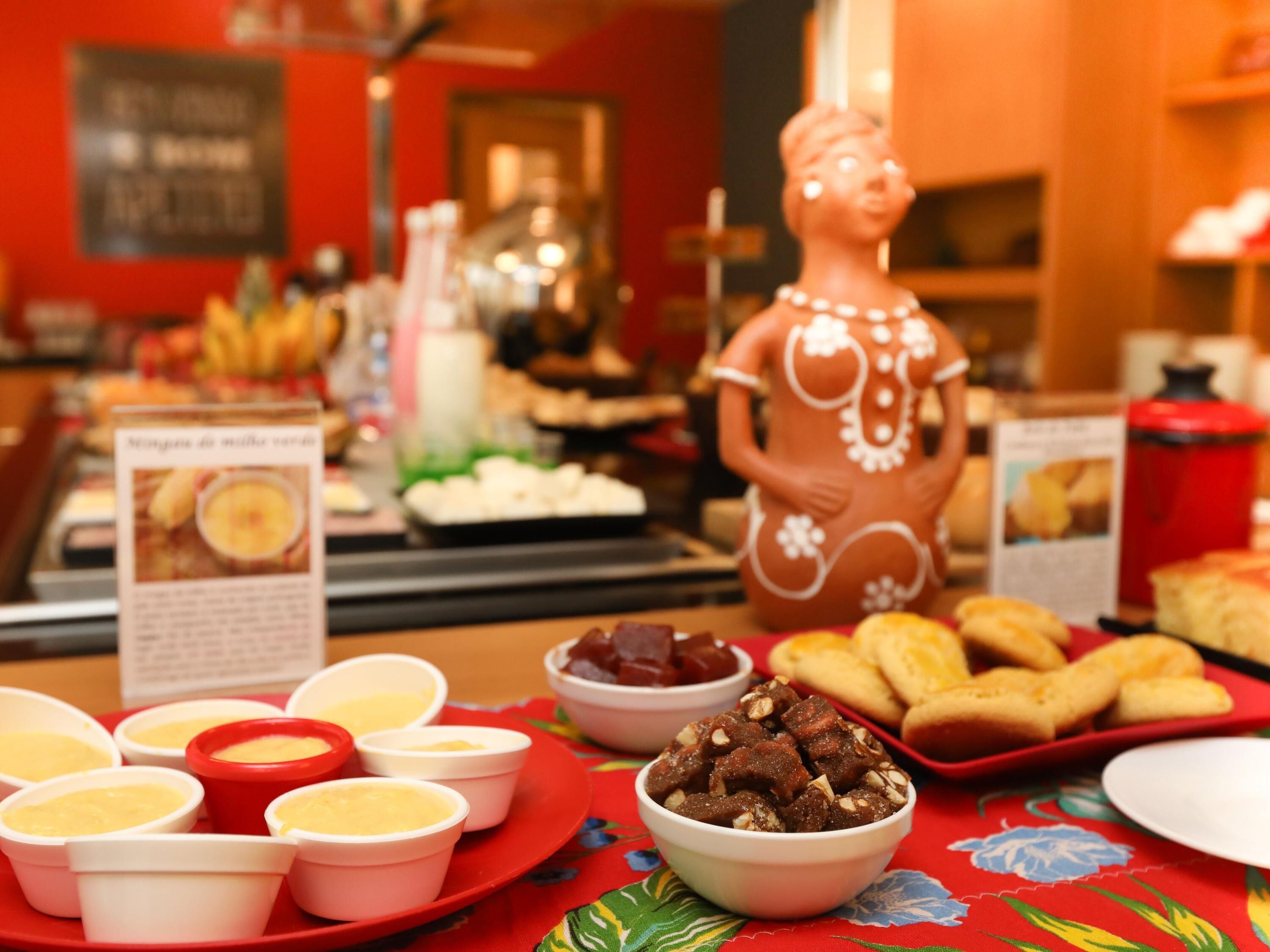 A buffet with various food items and a decorative statue.