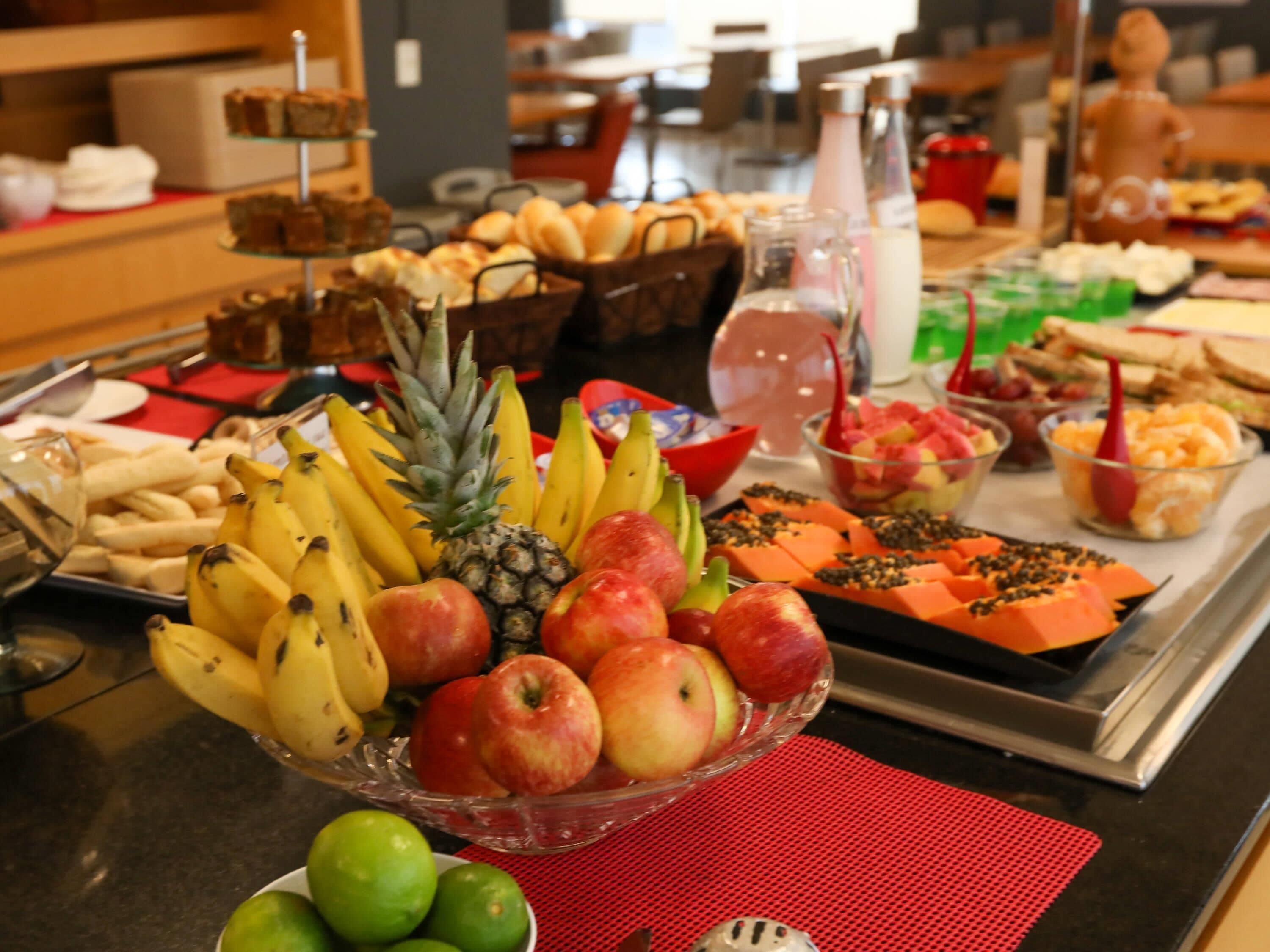 Un bufé con diversas frutas, bollería y bebidas.