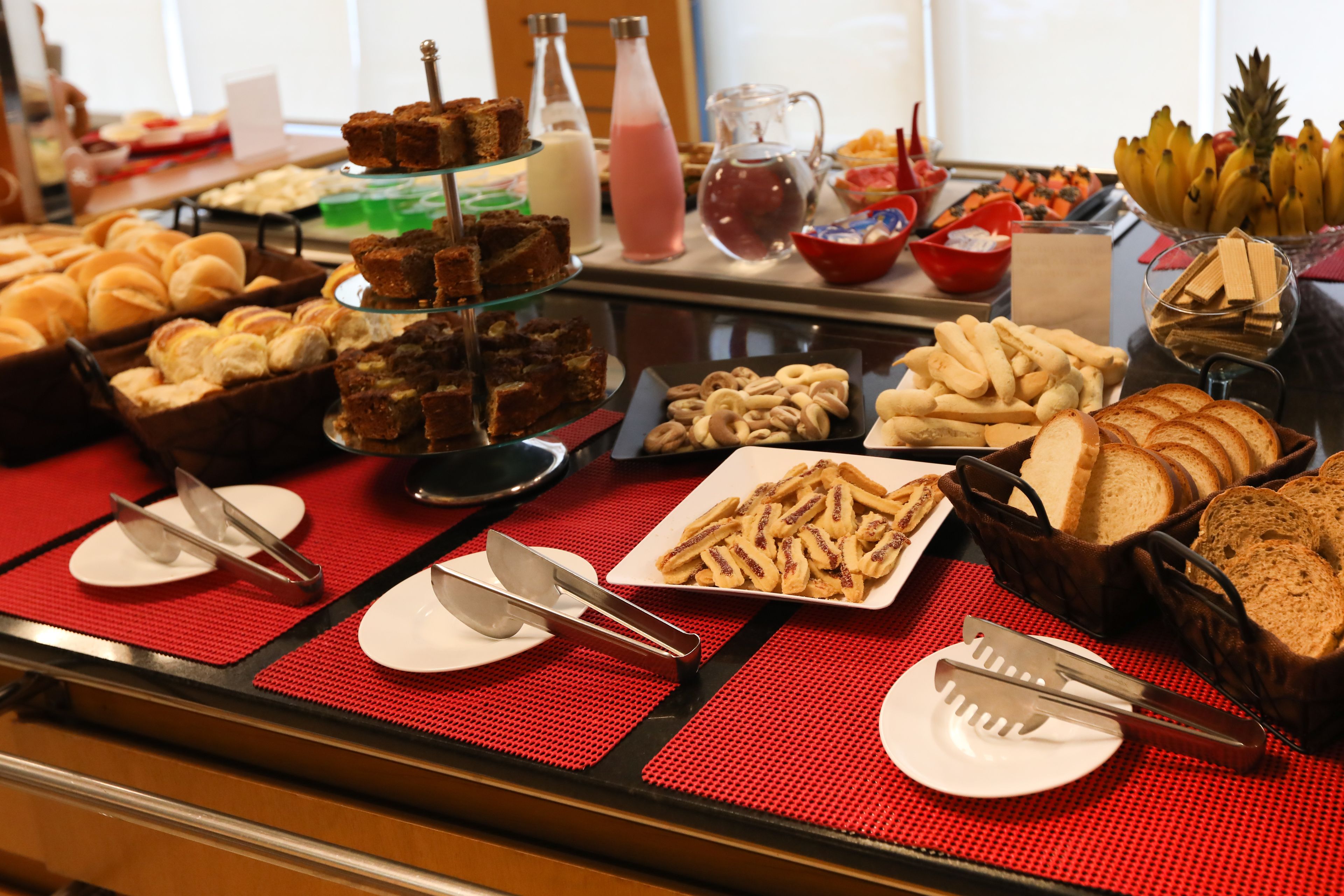 A buffet with various food items including breads, pastries, and desserts.