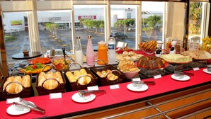 Un bufé con diversos alimentos y vista a un estacionamiento con un letrero 'maisa'.