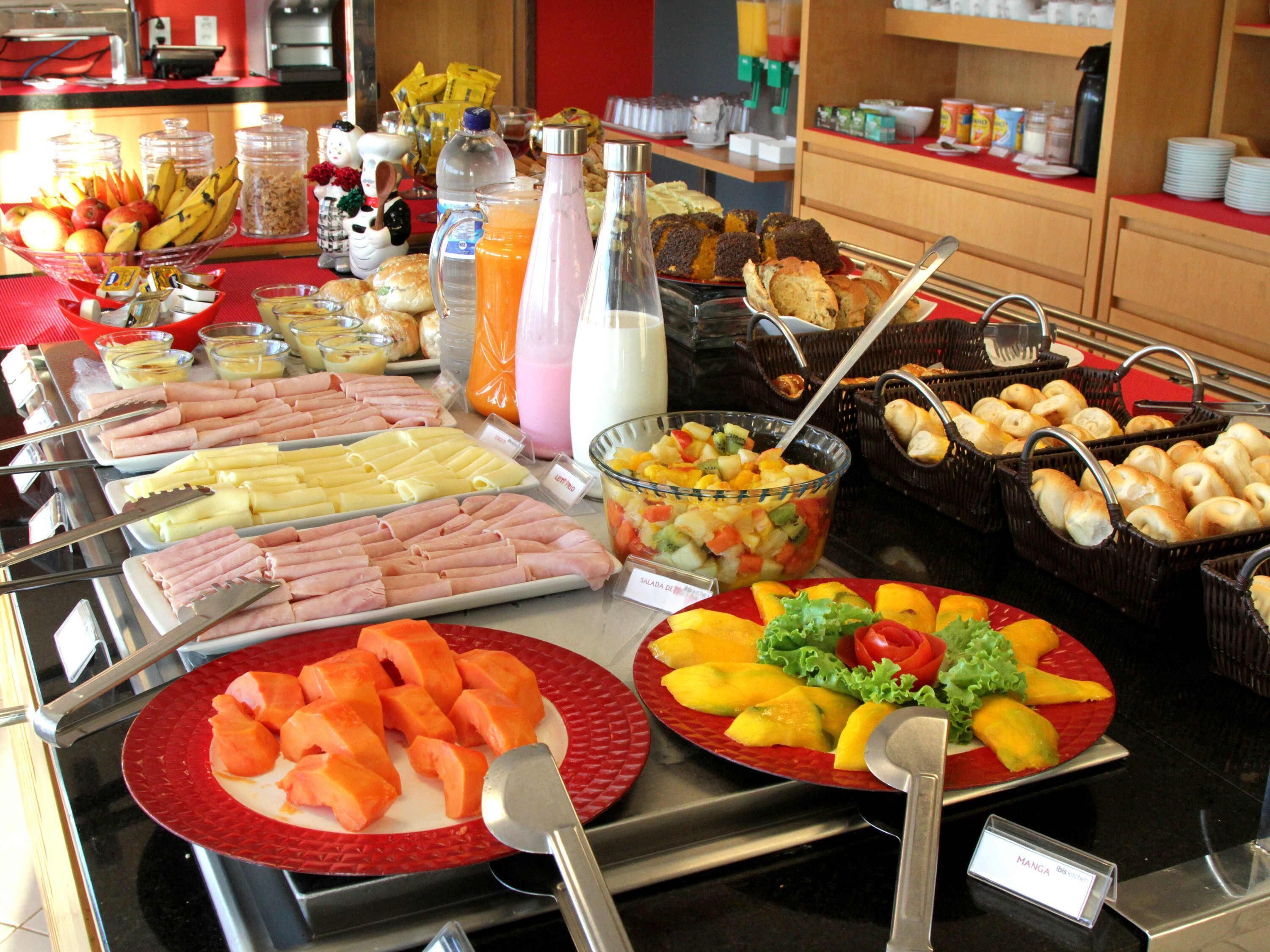 Buffet com diversos tipos de comida, incluindo frutas, legumes e carnes.