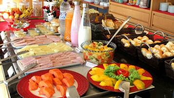 Buffet com diversos tipos de comida, incluindo frutas, legumes e carnes.