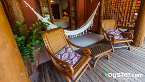 A wooden deck with two wicker chairs and a hammock. - Pousada Casa Do Forte (Mata de São João)