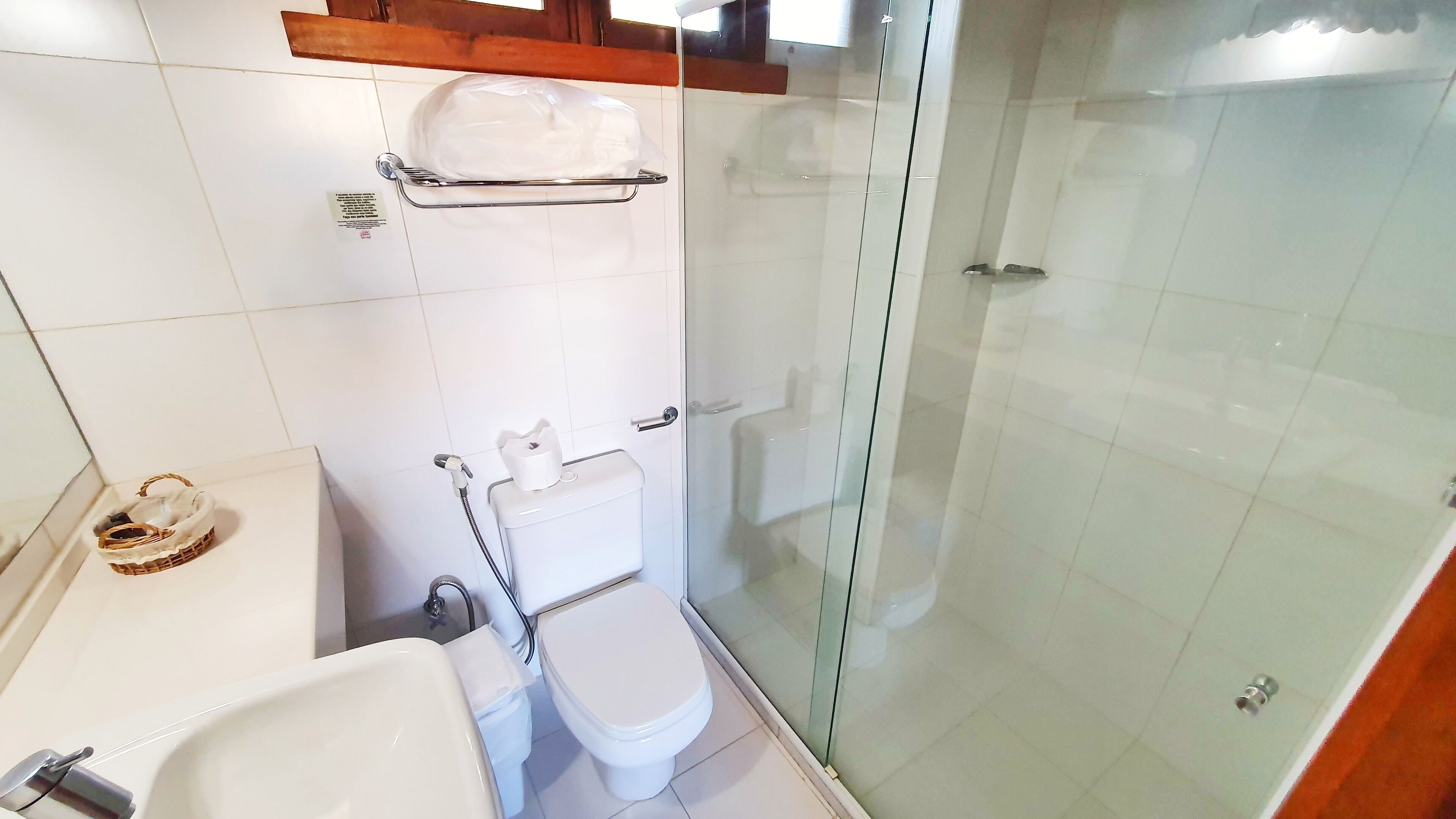 Une salle de bain équipée de toilettes, d’un bidet et d’une douche à parois de verre.