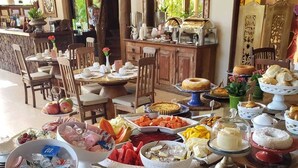 A buffet setup with various food items and condiments. - Pousada Casa Do Forte (Mata de São João)