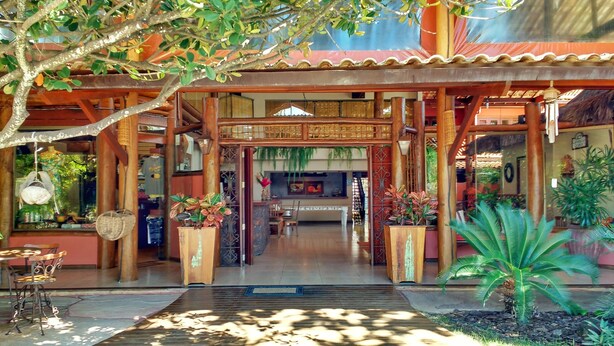 A traditional wooden structure with a tiled roof, a central entrance, and potted plants. - Pousada Casa Do Forte (Mata de São João)