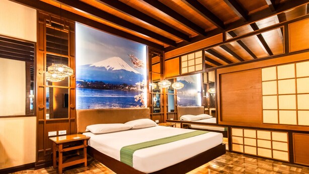 A hotel room with a large bed, wooden flooring, and a view of a snowy mountain through a window. - Hotel Ava Malate, Manila (Manila)