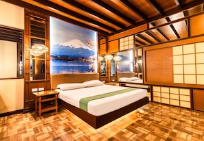 A hotel room with a large bed, wooden flooring, and a view of a snowy mountain through a window. - Hotel Ava Malate, Manila (Manila)