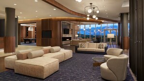 A spacious living area with a sectional sofa, armchairs, a coffee table, and a fireplace. - Courtyard by Marriott Calgary Airport (Calgary)
