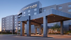 A modern hotel entrance with a flat roof and a sign reading "Courtyard by Marriott". - Courtyard by Marriott Calgary Airport (Calgary)