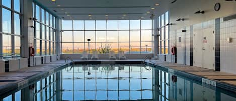 Una piscina techada, sillones reclinables de piscina