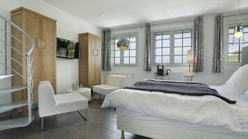 A modern bedroom with a bed, a desk, a chair, and a wardrobe.