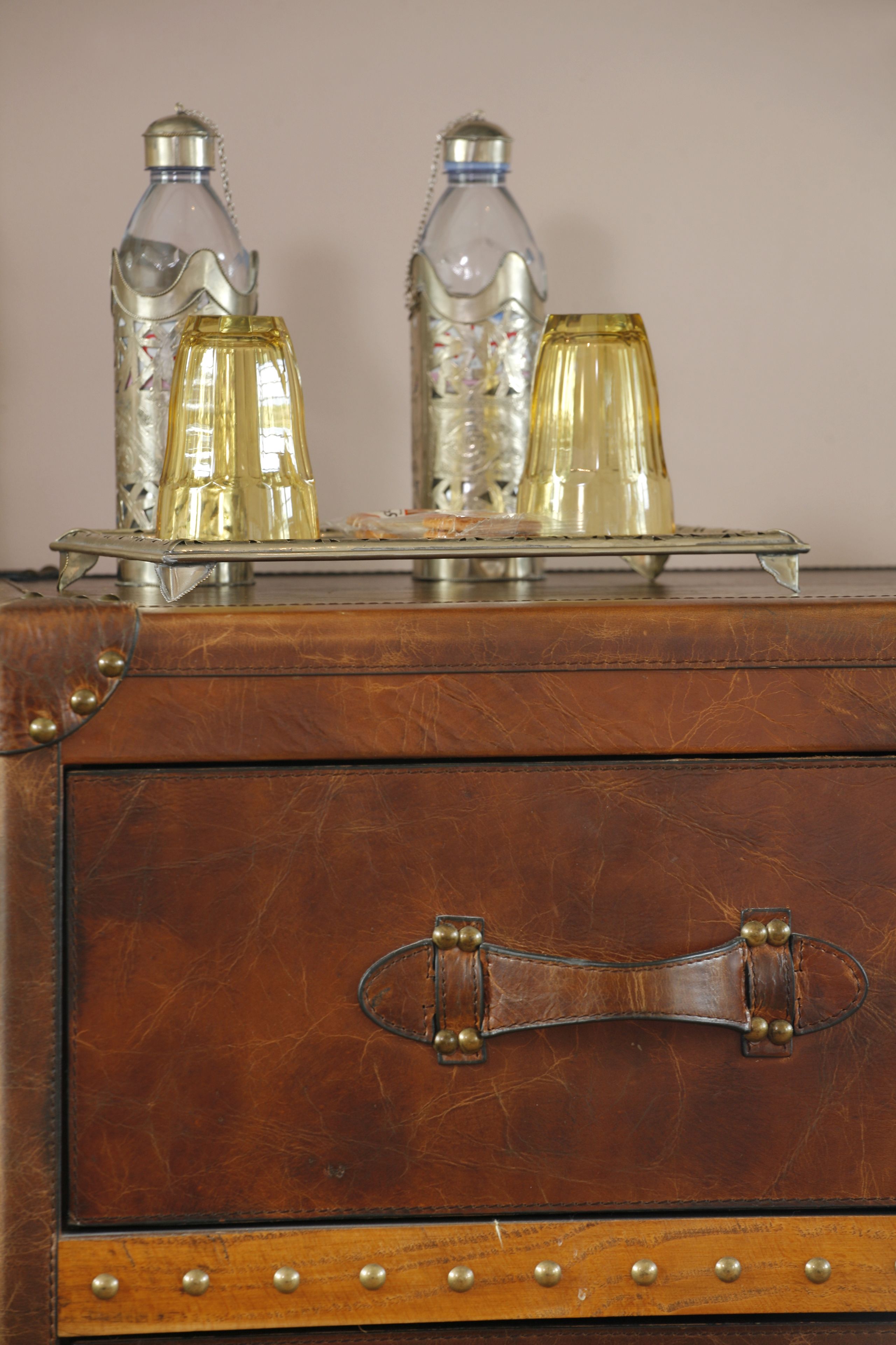 A vintage suitcase with metal clasps and decorative elements.