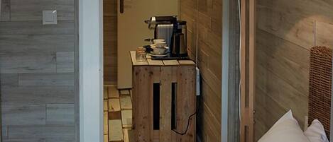 Une petite pièce comprenant un lit, une armoire en bois et une lampe suspendue.