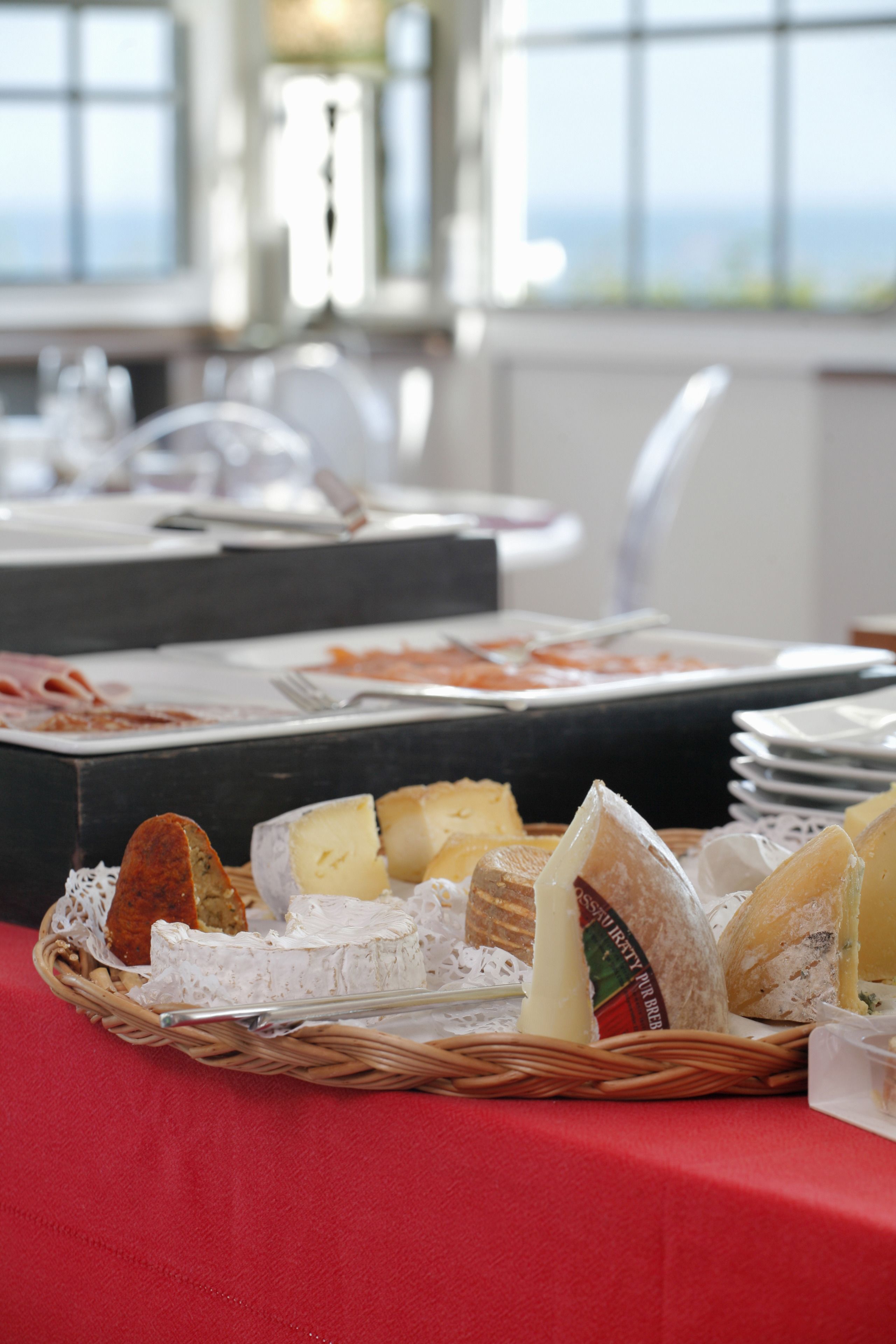 Une table de buffet avec différents types de fromages et de pains.