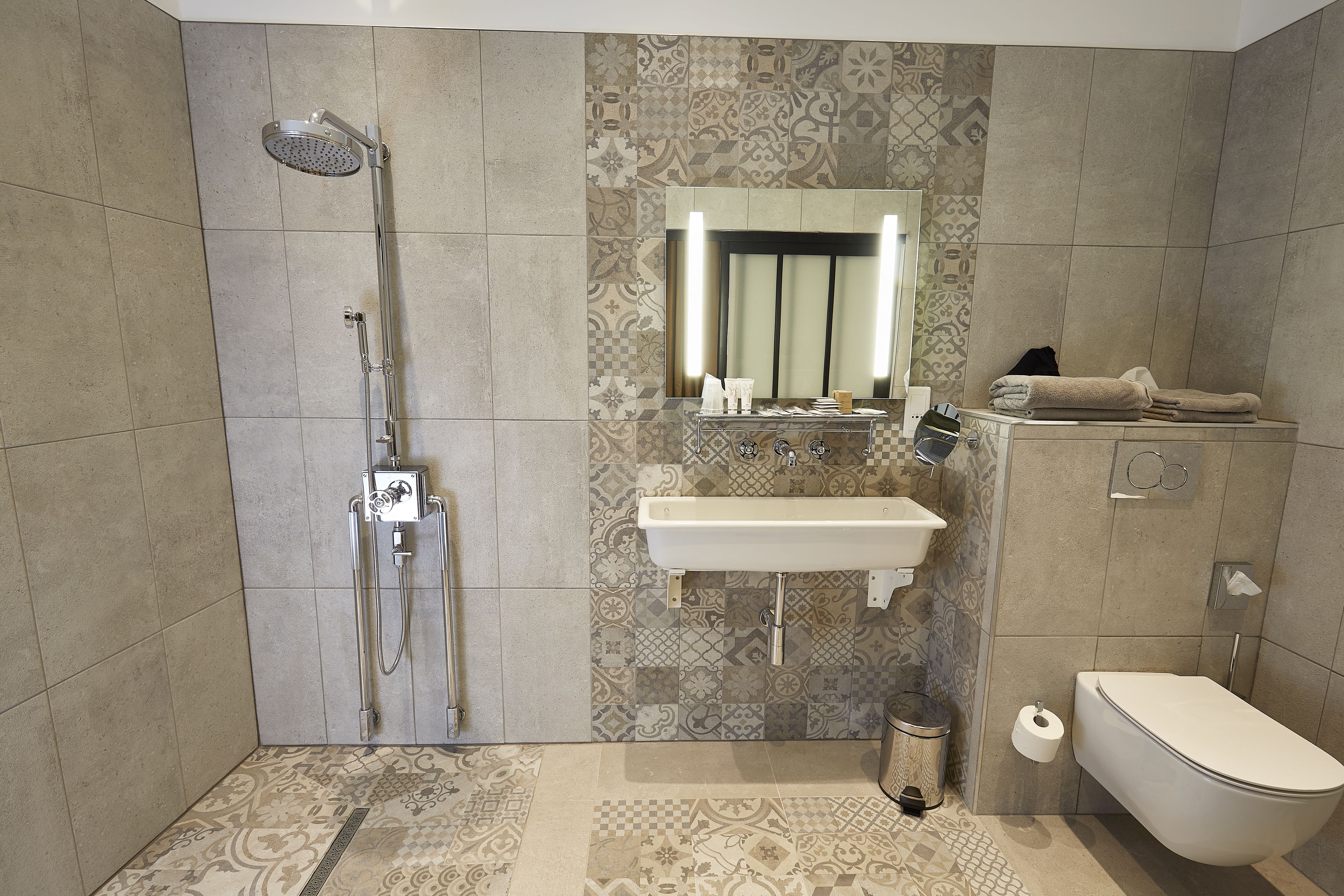 A modern bathroom with a shower, sink, and toilet.