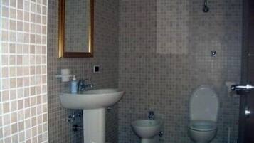 A bathroom with a sink, bidet, and toilet.