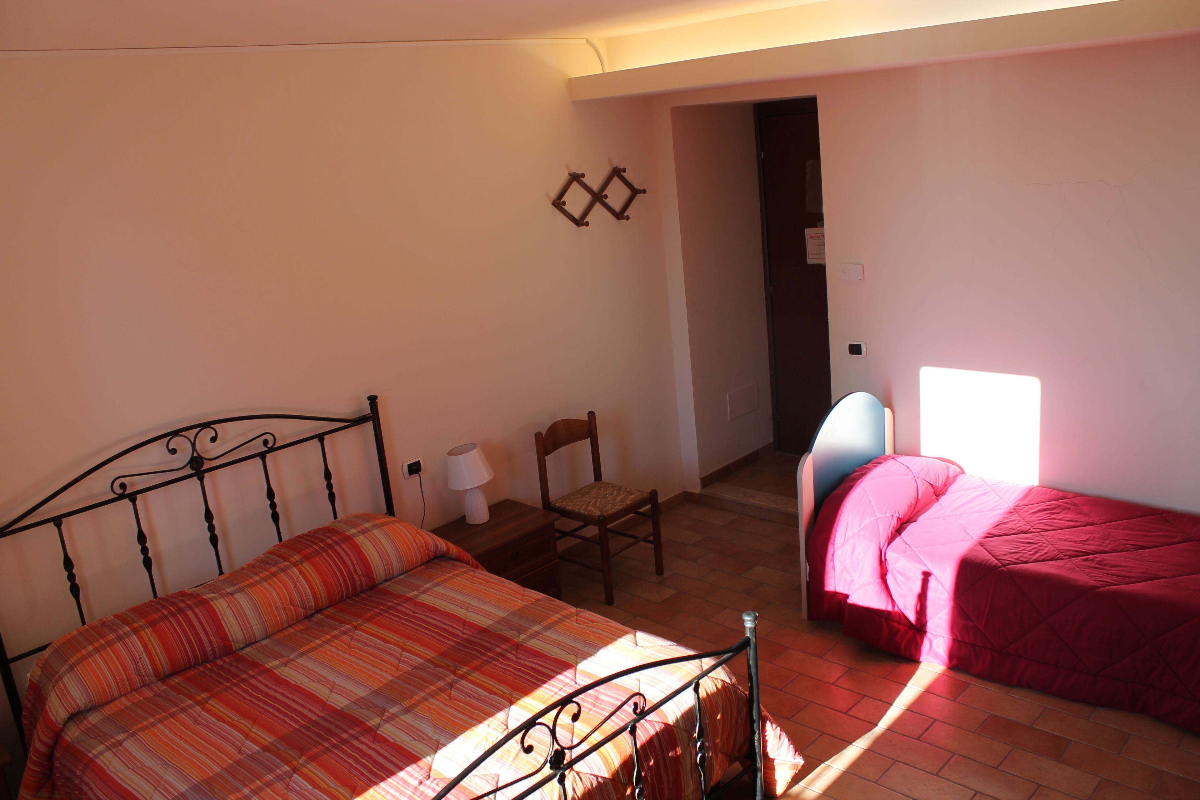 A bedroom with a bed, a chair, and a desk.